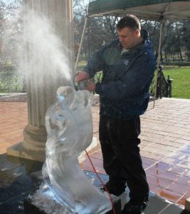 a man carving a Ice Sculpture with a machine