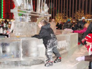 a little boy standing near an Ice Sculpture